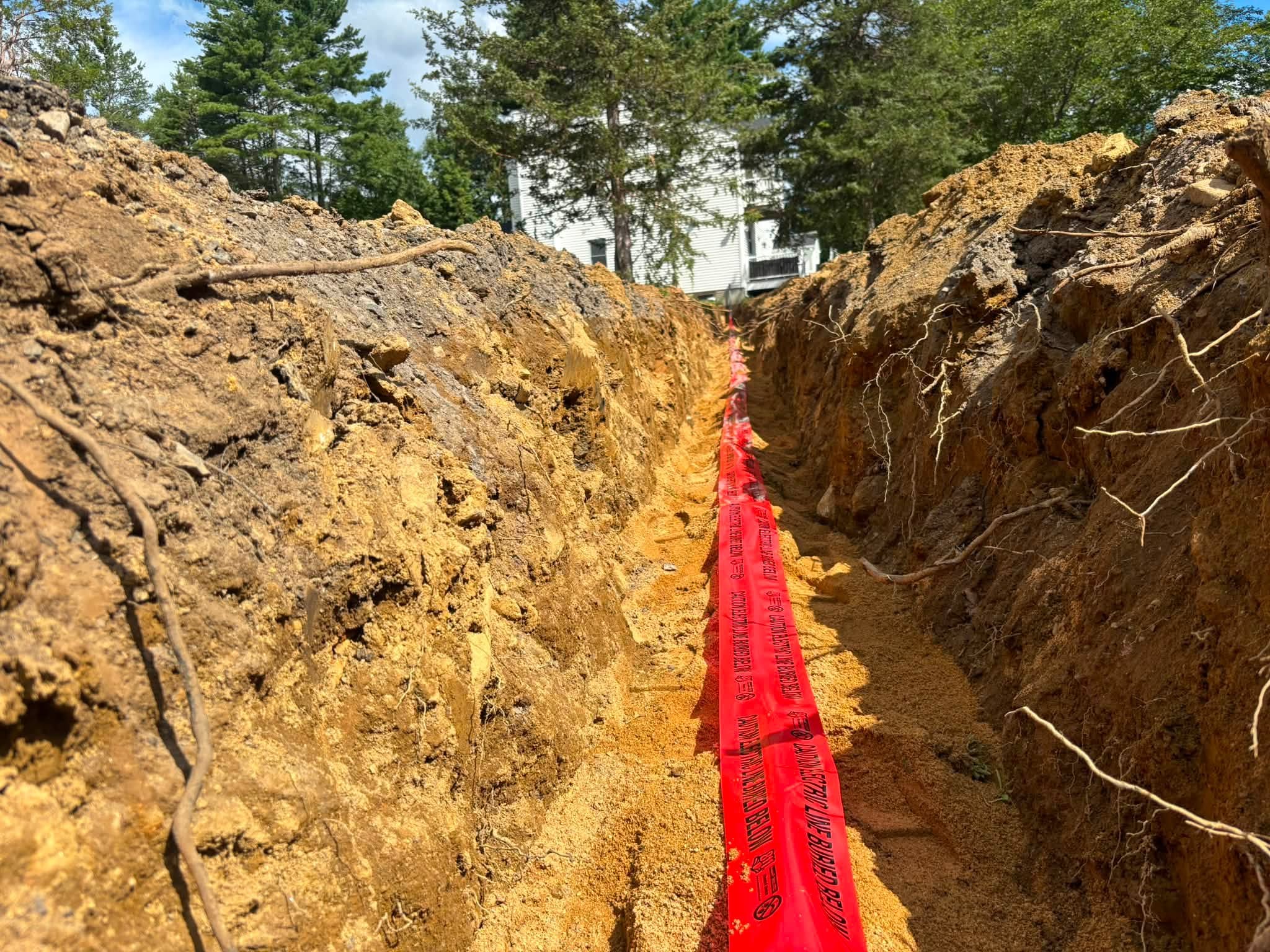 Trench with caution tape during utility installation